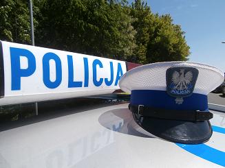 Zdjęcie przedstawia dach policyjnego radiowozu, na którym leży policyjna czapka policjanta ruchu drogowego.