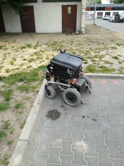 Na zdjęciu widoczny jest elektryczny wózek inwalidzki.